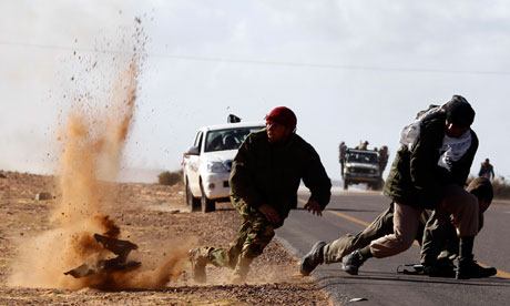 Libyan opposition fighters try to cover from tank shelling near the eastern town of Ajdabiya. Senior Liby